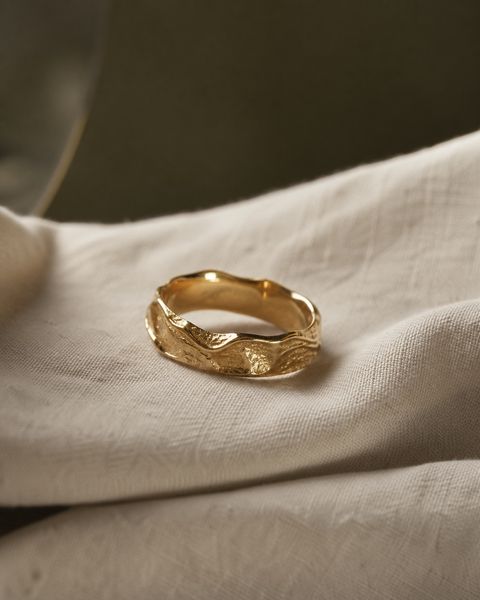 A gold ring resting on cream linen